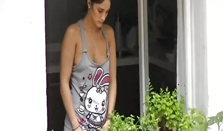 Hermosa mujer mintiendo películas de pornografía en la striped sofá